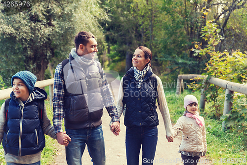Image of happy family with backpacks hiking in woods