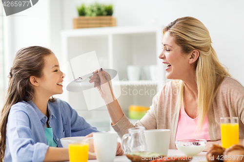 Image of happy family having breakfast at home kitchen