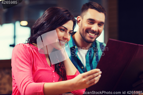 Image of smiling couple with menus at restaurant