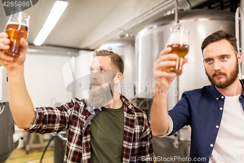 Image of men drinking and testing craft beer at brewery