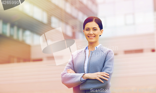 Image of young smiling businesswoman over office building