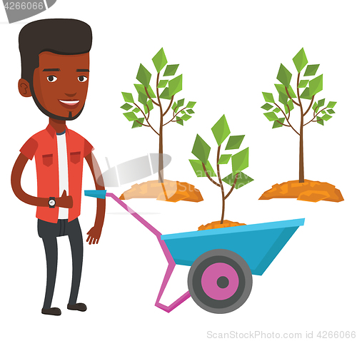 Image of Man pushing wheelbarrow with plant.