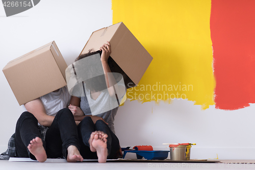 Image of young multiethnic couple playing with cardboard boxes