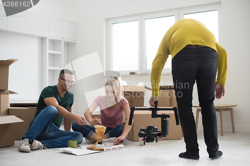 Image of young couple have a pizza lunch break on the floor