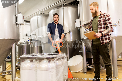 Image of men with malt and clipboard at craft beer brewery