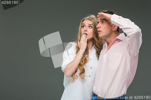 Image of Portrait of a young couple standing against gray background