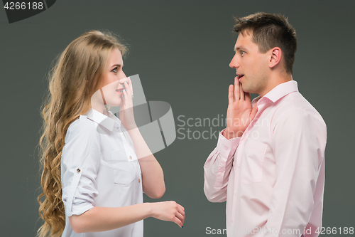 Image of Portrait of a young couple standing against gray background