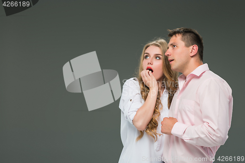 Image of Portrait of a young couple standing against gray background