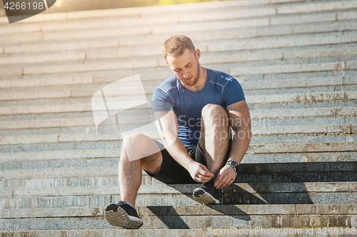 Image of Fit man doing exercises outdoors at park