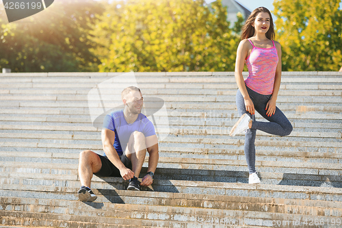 Image of Fit fitness woman and man doing stretching exercises outdoors at park