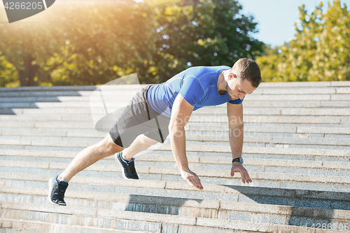 Image of Fit man doing exercises outdoors at park