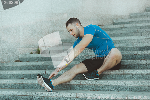 Image of Fit man doing exercises outdoors at park