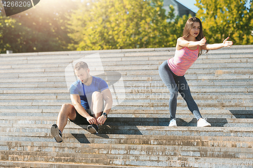 Image of Fit fitness woman and man doing stretching exercises outdoors at park