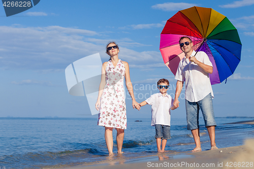 Image of Happy family walking on the beach at the day time.