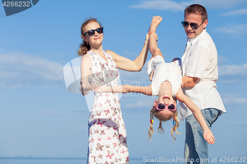 Image of Happy family walking on the beach at the day time.