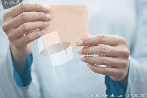 Image of Yoga instructor holding adhesive note