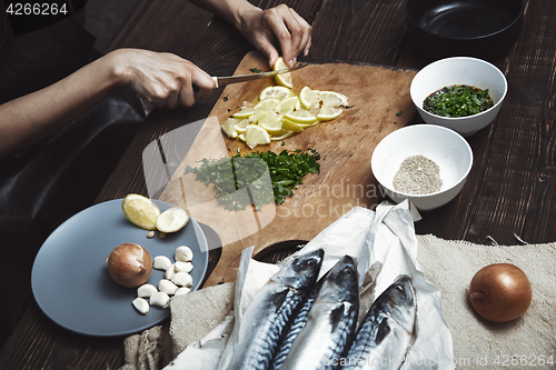 Image of Woman cutting lemon for fish stuffing