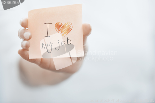 Image of woman holding adhesive note with text