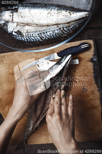 Image of Woman preparing mackerel fish