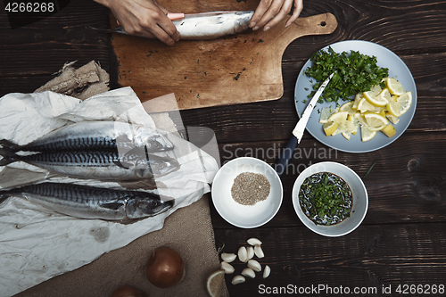 Image of Woman preparing mackerel fish