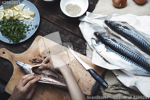 Image of Woman preparing mackerel fish