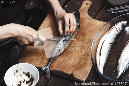 Image of Woman preparing mackerel fish