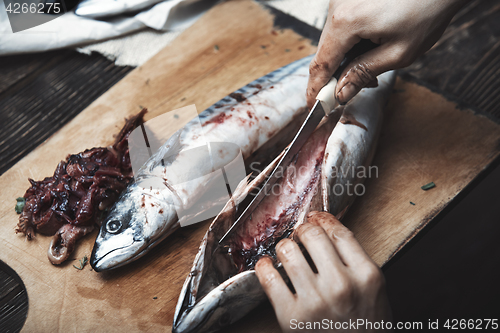 Image of Woman preparing mackerel fish