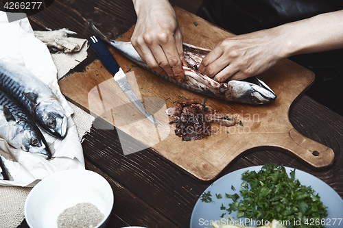 Image of Woman preparing mackerel fish