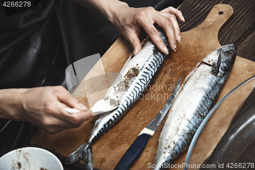 Image of Woman preparing mackerel fish