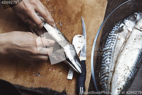 Image of Woman preparing mackerel fish