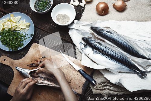 Image of Woman preparing mackerel fish