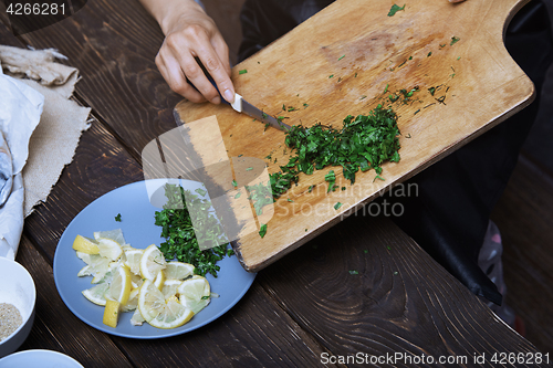 Image of Woman cutting culinary plants and vegetables