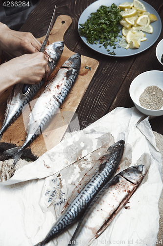 Image of Woman preparing mackerel fish