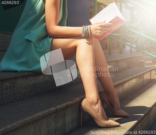 Image of woman with beauty leg holding a book