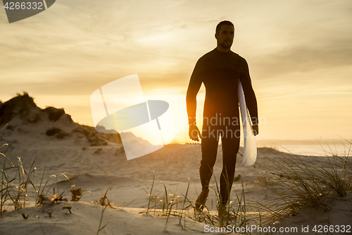 Image of A surfer with his surfboard 