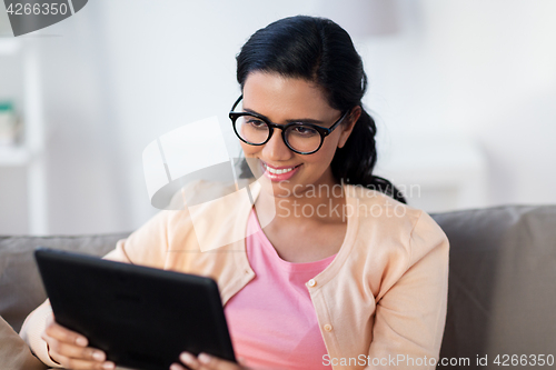 Image of happy indian woman with tablet pc at home