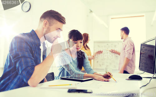 Image of creative team with blueprint at office