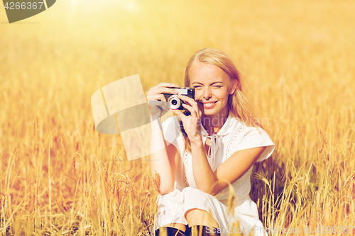 Image of happy woman with film camera in wreath of flowers