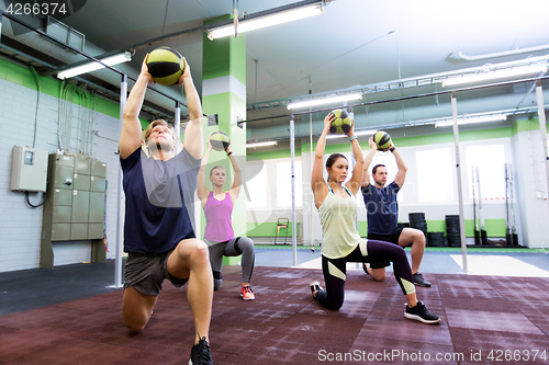 Image of group of people with medicine ball training in gym