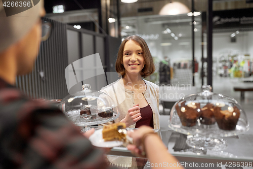 Image of man or barman with cake serving customer at cafe