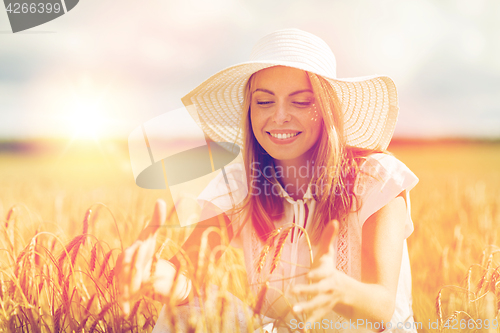 Image of happy young woman in sun hat on cereal field