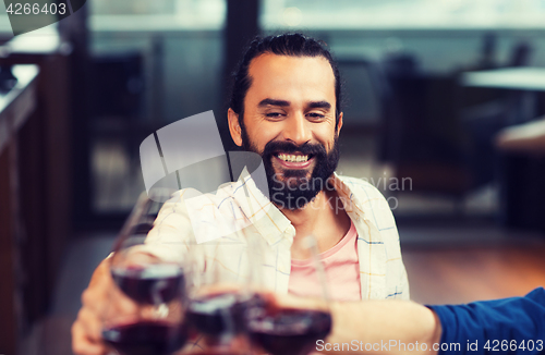 Image of happy man clinking glass of wine at restaurant