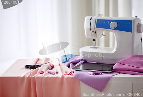 Image of sewing machine, tablet pc, scissors and ruler