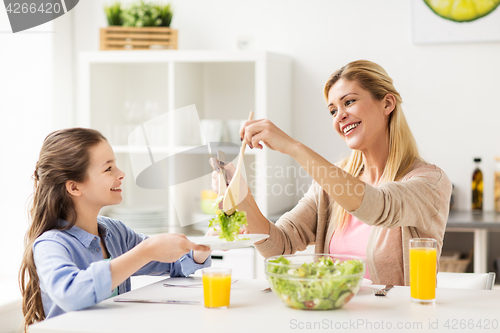 Image of happy family eating salad at home kitchen