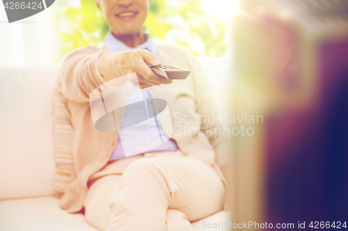 Image of close up of happy senior woman watching tv at home