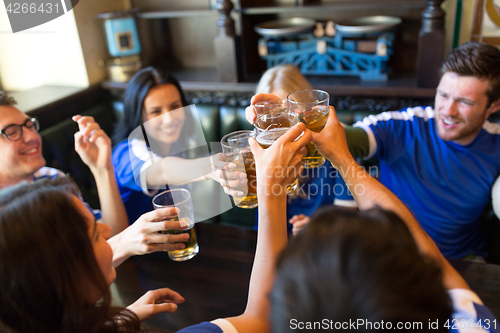 Image of football fans clinking beer glasses at sport bar