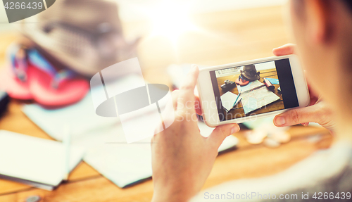 Image of close up of woman with smartphone and travel stuff