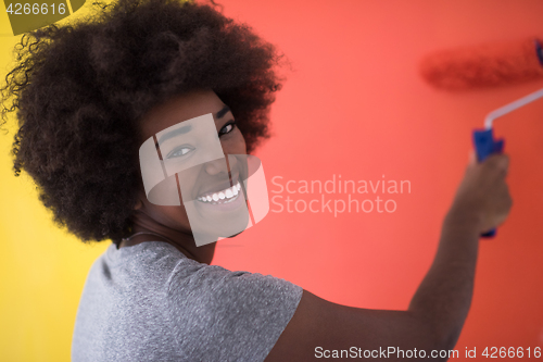 Image of black woman painting wall