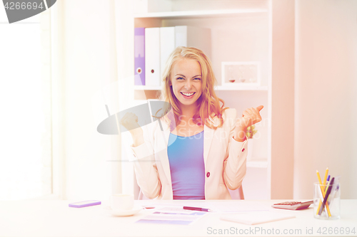 Image of happy businesswoman celebrating success at office