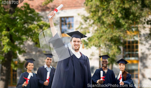 Image of happy students in mortar boards with diplomas